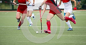 Field hockey players challenge eachother for possession of the ball on the midfield battle of a hockey mach