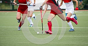 Field hockey players challenge eachother for possession of the ball on the midfield battle of a hockey mach photo