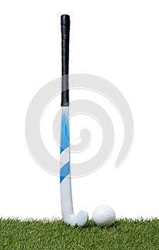 Field hockey stick and ball on the green field. Professional sport concept