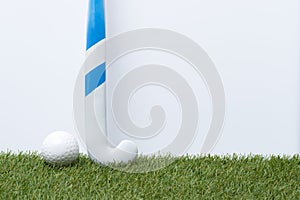 Field hockey stick and ball on the green field. Professional sport concept