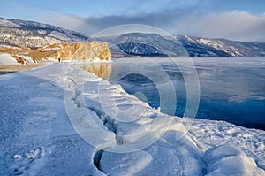 Field of ice hummocks and rock on the frozen Lake Baikal. Sunrise