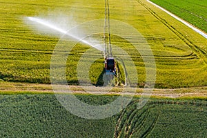 Field with irrigation sprinkler seen from above