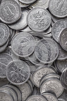 Field of Japanese coins at 1 yen close-up. Dark background or wallpaper with aged effect. News about the economy, finance and