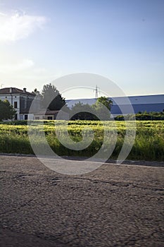 Field and manor next to a warehouse