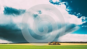 Field Or Meadow Landscape With Green Grass Under Scenic Spring Blue Dramatic Sky With White Fluffy Clouds. Rain Clouds