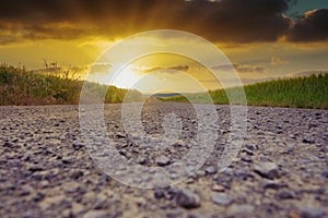 Field path to a sunset on a cloudy sky