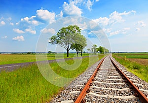 Field with railway rails, roads and blue sky. Landscape of the periphery