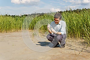 Field researcher biologist examines soil sample in vitro