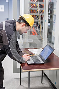 Field service engineer inspect relay protection system with laptop comput