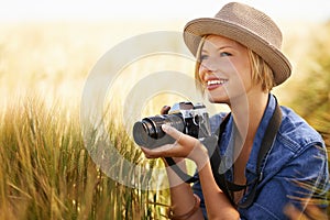 Field, smile and woman with a camera, photographer and sunshine with tourism, travelling and nature. Person, photography