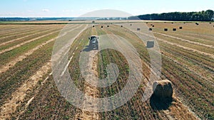 Field with a tractor and multiple piles of hay