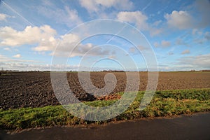 Fields and meadows along Hollandsche IJssel river with blue sky and white clouds. The polder behind the is named zuidplaspolder an