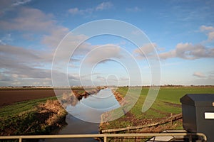 Fields and meadows along Hollandsche IJssel river with blue sky and white clouds. The polder behind the is named zuidplaspolder an