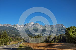 Fields, road, forest, alpine landscape and blue sky in Saint-Gervais-Les-Bains photo