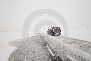 Fields and a road in winter and a car