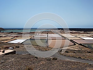 The fields for salt mining on the banks of the Atlantic Ocean. Blue horizon, turquoise water