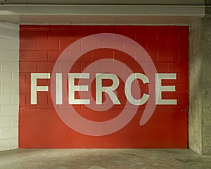 FIERCE painted in bold white letters on a red painted brick wall in the parking garage on Victory Park Lane, Dallas, Texas