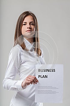 Business plan displayed, white shirt, brown-haired woman photo