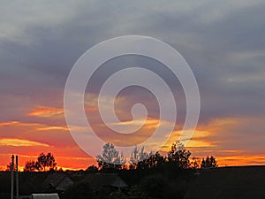 Fiery clouds in the rays of the setting sun
