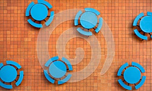 Fiery orange, square tile patio and blue tables.