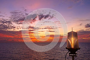 Fiery orange sunset sky warm light with clouds on the sea Beautiful for background with nav aids lamp on offshore oil and gas