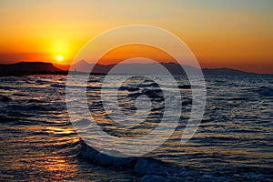 Fiery red sunset over a turbulent sea