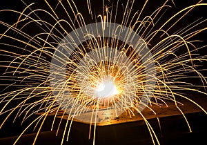 Fiery welding sparks exploding outward against a dark background