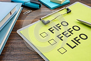 FIFO FEFO LIFO warehouse management strategies with clipboard.