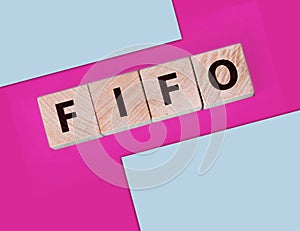 FIFO First in, first out word on wooden cubes on blue. Accounting Concept