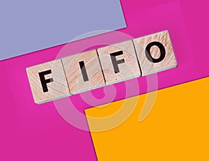 FIFO First in, first out word on wooden cubes on blue. Accounting Concept