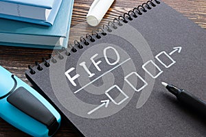 FIFO or first in first out concept. Notepad with a drawn diagram on the table.