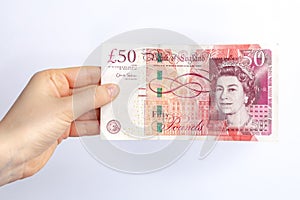 Fifty english pounds banknote in woman`s hand. Concept of paying taxes in the end of a year. photo