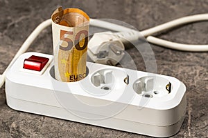 Fifty euro banknote inserted into an extension socket