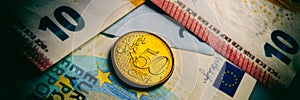 Fifty euro cent coin lies on euro bank notes