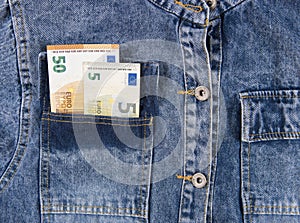 Fifty euro notes in pocket of blue jeans shirt.  European union money bills in jeans pocket, close-up