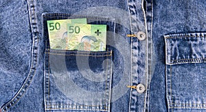 Fifty euro Swiss franc notes in pocket of blue jeans shirt.  Swiss franc.money bills in jeans pocket,