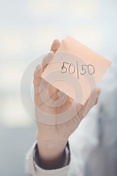 Fifty-fifty text on adhesive note