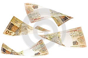 Fifty reais banknotes from Brazil falling on isolated white background. Concept of falling money, devaluation of the real or photo