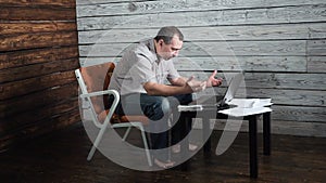 Fifty year old crazy man checks online account and celebrates winning on his laptop computer