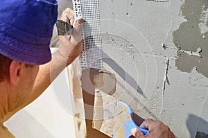 Fifty years old manual worker with wall plastering tools renovating house