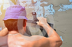 Fifty years old manual worker with wall plastering tools renovating house