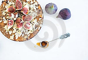 Fig cake with fresh figs, honey and almond flakes on white