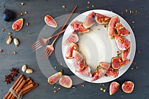 Fig cake with pistachios and white frosting, above view table scene over slate