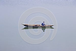 A figherman sitting on the boat with speacial replection photo