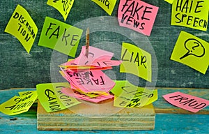 Fight against fake news concept,sticky notes with fake news topics spiked on a nail, focus on forground,close up