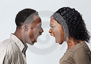 Black man and woman fighting over grey background photo