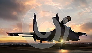 Fighter jet on air force base airfield getting ready to take off at sunset