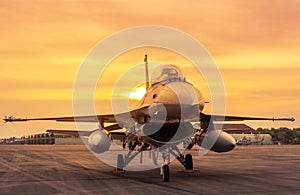 Fighter jet military aircraft parked on runway on sunset