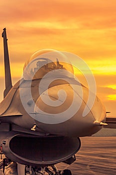 Fighter jet military aircraft parked on runway on sunset
