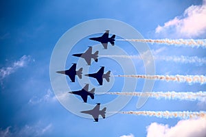 Fighter jets in formation flying past clouds